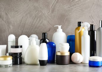 Different body care products on table against grey background
